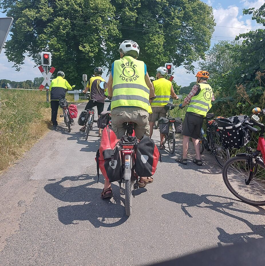 Sowas soll's geben: eine geschlossene Schranke auf einsamer Flur! Die Gruppe versammelt sich am geschlossenen Bahnübergang