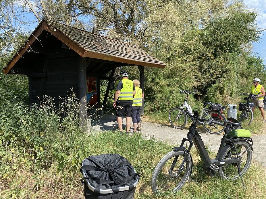 Erste Pause am Auesee Nordufer Die Gruppe macht Pause am Auesee Nordufer, ein Unterstand bietet Schatten.