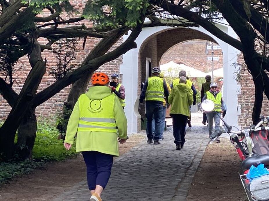 Geldern, Schloss Haag Die gelb gewandete Gruppe geht durch das Burgtor in das Schloss Haag
